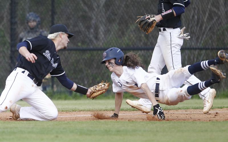 Diamond Devil senior Carson Pullen tags senior War Eagle Jeremy Humphries in the third inning of Elbert County’s 8-7 region win at Putnam County March 13 in Eatonton. (Photo by Cary Best)