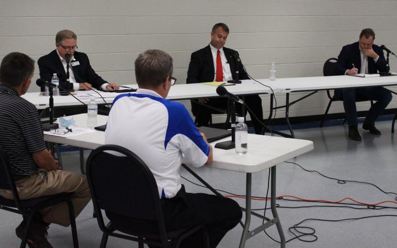 Elberton Star Publisher Gary Jones (L) and WSGC Radio’s Linton Johnson (R) in the foreground asked Georgia House Rep. District 33 candidates questions at last week’s forum at the county government complex – the candidates are (L-R) Bruce Azevedo of Madison County, Rob Leverett of Elbert County and Tripp  Strickland of Madison County. (Photo by Scoggins)