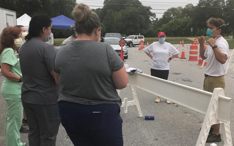 Patrick Reilly (right), who has coordinated free COVID-19 tests in Elberton for the past three weeks, briefs staffers prior to testing Monday morning as cars line up for testing. (Photo by Jones)