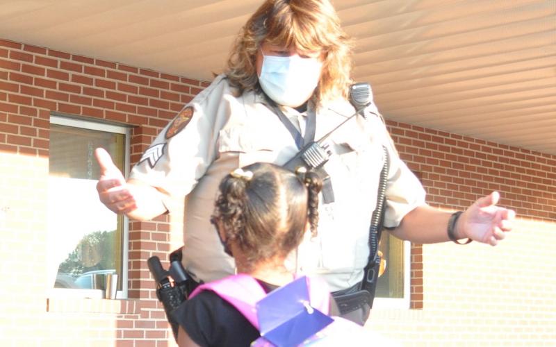 Elbert County School Resource Officer Tammy Gilliard welcomes a student on the first day of school at Elbert County Primary School Monday. (Photo by Jones)