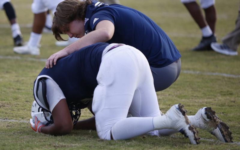 Injured junior Sam Lavender consoles senior C.J. Tate after Elbert County fell to Bremen 28-21 in the first round of the state playoffs Saturday in the Historic Granite Bowl. Other seniors playing their final game in the Granite Bowl included Mehki Davenport, Quin Hall, Q.T. Teasley, Nolan Johnson, Nate Lavender, Tyshawn Hughes, Austin Duck, L.J. Browner and A.J. German. The Blue Devils defeated Union County and Banks County in the region to reach the first round of the state playoffs. (Photo by Scoggins)