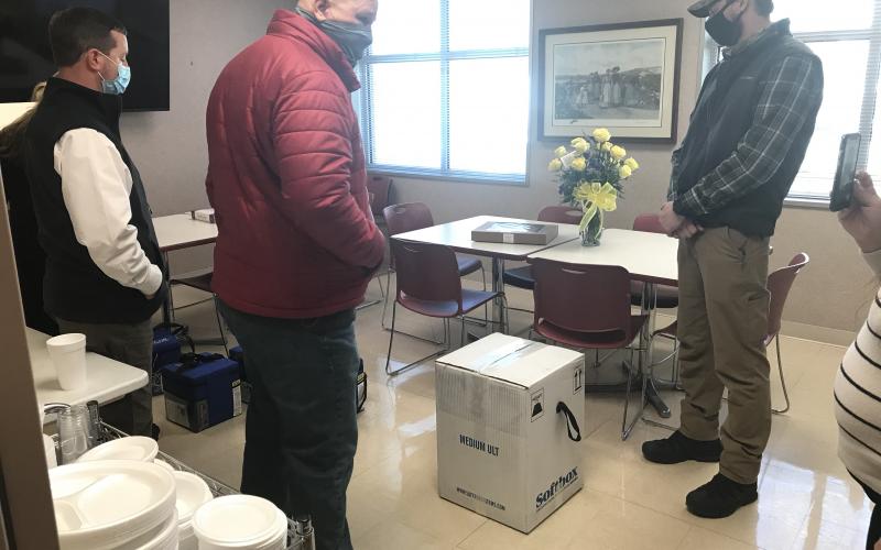 Ryan Rutan (far right), was later identified after Tuesday’s seizure of Pfizer vaccines as an employee of the Georgia Department of Public Health. The two men shown on the left have still yet to be identified. The group is standing around a box full of frozen vials of the Pfizer vaccine. The Elberton Star is sending an open records request to the Georgia Department of Public Health to identify the men and the agency they work for. (Photo by Jones)