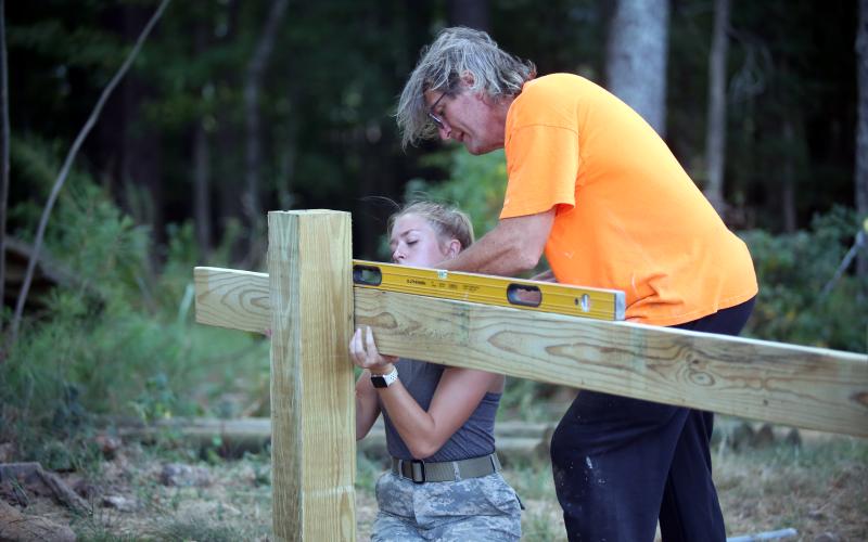 Isabella (left) and Scott Harpold (right) work together to construct the new obstacle course for the JROTC program. (Photo by Wells)