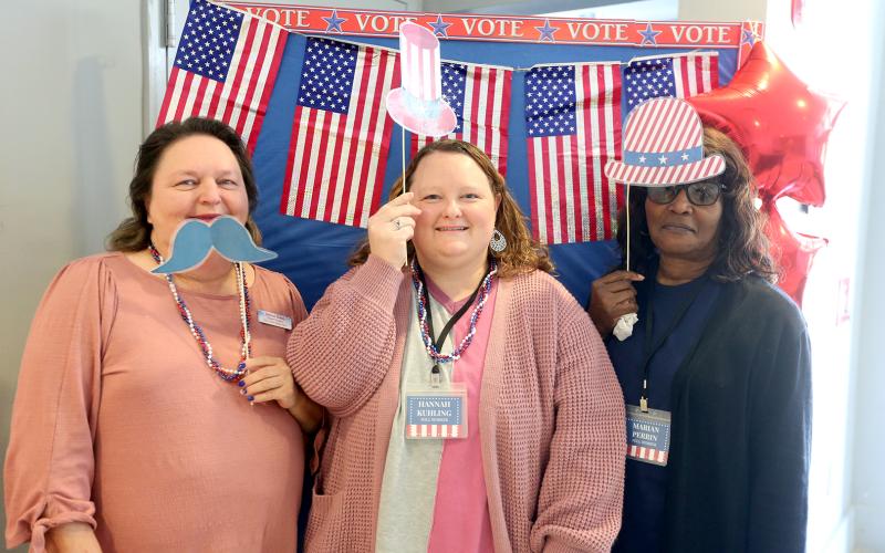 Elections Supervisor Melissa Shead (left) and poll workers (L-R) Hannah Kuhling and Marian Perrin pose for a picture in the foyer of the Historic Rock Gym. A "selfie station" has been set up for voters to take a picture with props after casting their vote in the Presidential Preference Primary. Photos can be shared with the Board of Elections and Registration Office by emailing voteec@elbertga.us for a chance to be featured on the office's Facebook page. (Photo by Scoggins)