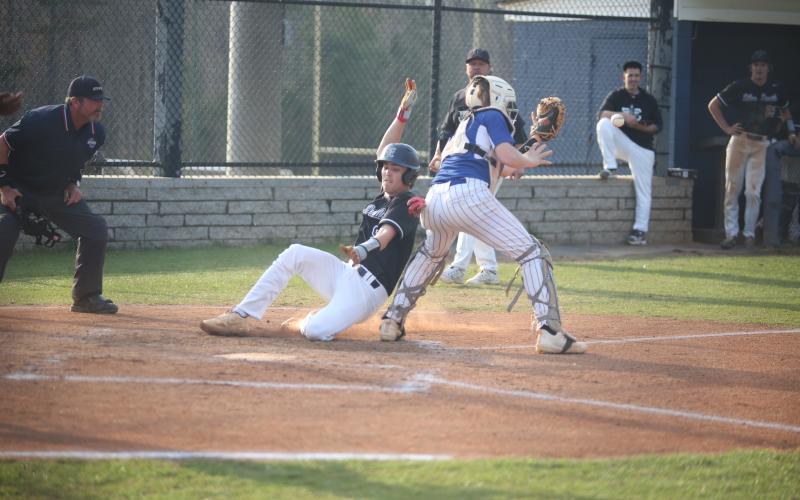 Brooks Banks slides past the Oglethorpe catcher and reaches for the plate as he scores a run for the Diamond Devils in their 10-0 win over the Patriots March 21. Banks finished the game with a home run, two hits, two runs and two RBIs. (Photo by Wells)