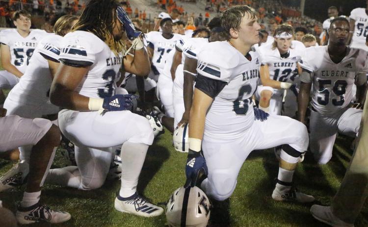 Blue Devils (L-R) Tamar Burton, Seth Capps and A.J. German take a knee to listen to head coach Brad Waggoner after losing to Hart County Friday night Aug. 23 in Hartwell. (Photo by Cary Best)