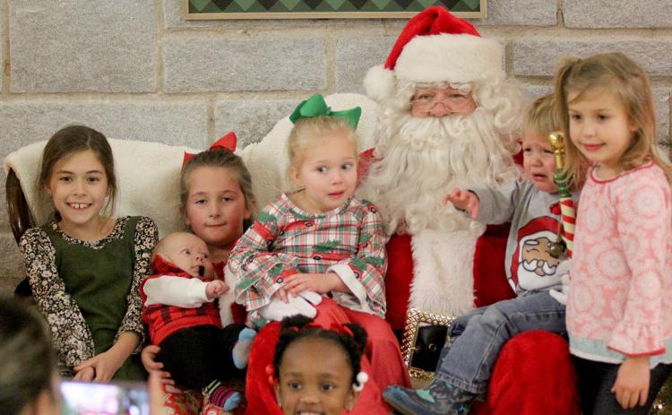 Santa Claus stopped by the Historic Rock Gym to visit families from the Elbert County Sheriff’s Office Thursday, Dec. 17 and received mixed reactions during picture time. Pictured with Santa are (front row) Ariyah Heard and (second row, L-R) Zoey Allen, Madelyn Frady and Lawson Dove, Hadley Frady, Kamdyn Harris, and Kendal Harris. (Photo by Wells)
