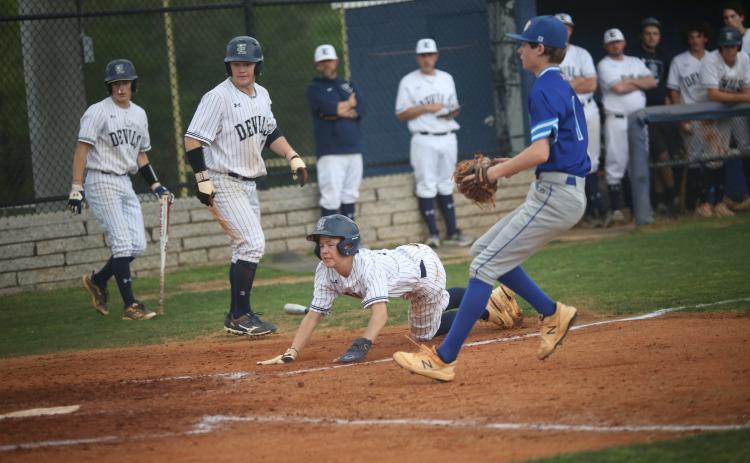Diamond Devils (L-R) Eli Harris and Skyler Bray watch as Brayden Ingram slides safely into home plate during a doubleheader against region opponent Barrow April 6. (Photo by Wells)