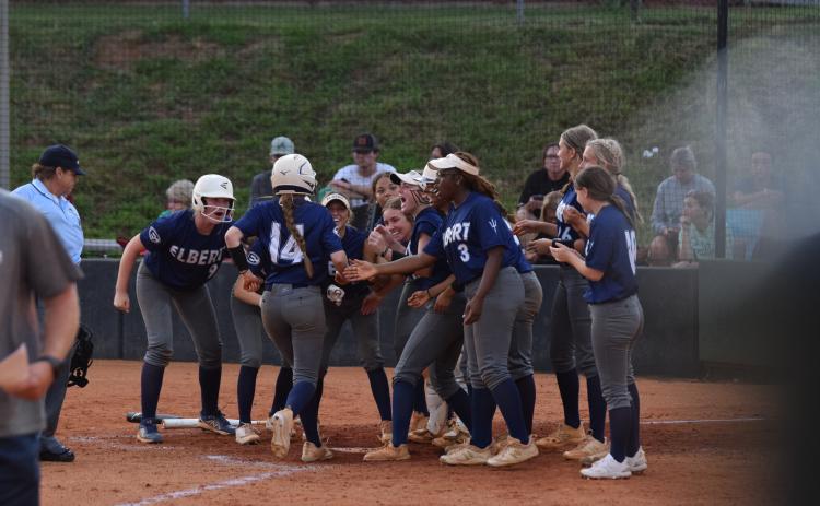 Miller Drake (No. 14) is greeted by her teammates at the plate after smashing a home run to center field during Elbert County’s 9-8 loss to Franklin County Aug. 15. (Photo by Shane Scoggins, Franklin County Citizen