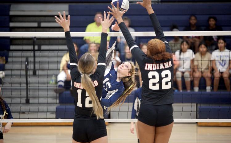Elbert County Volley Devil Johna Johnson hits the ball over the net as two Stephens County players try to block her shot. (Photo by Wells)
