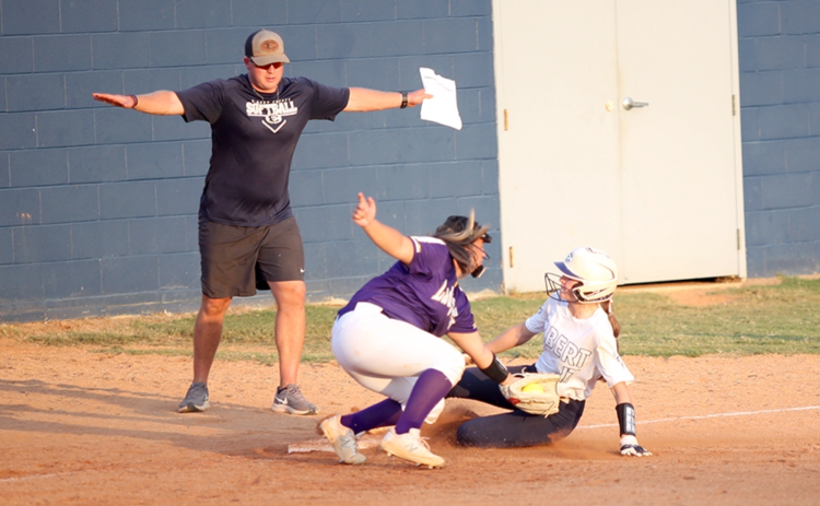 Head Coach Drew Greer signals “safe” after Miller Drake slides into third base. Drake was one of seven different Lady Devils to steal a base against Athens Christian. (Photo by Wells)