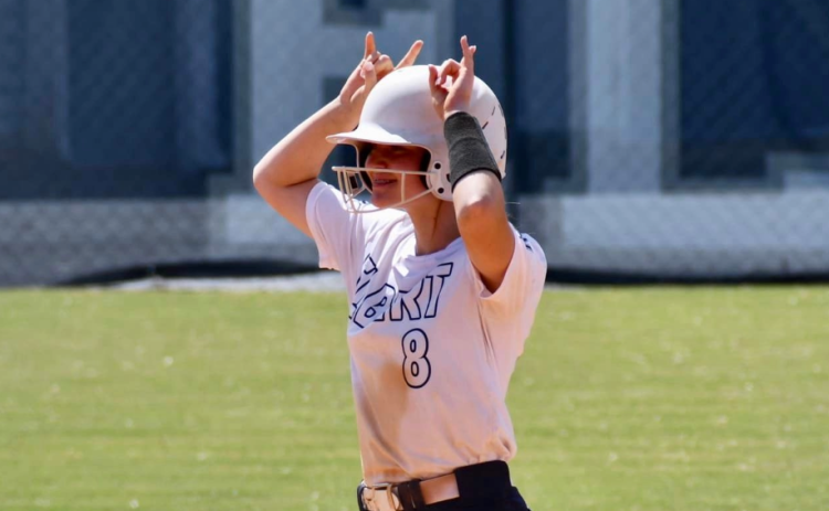 Erica Christian does the Devil sign to the Elbert County dugout after reaching base safely in Elbert County’s 17-1 win over Academy of Richmond County Sept. 30. (Photo by Bethany Booth)