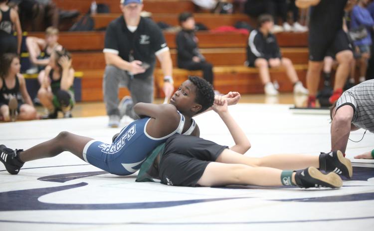Ny’Zaevion Merriett looks to his coaches as he attempts to pin a Youth Middle School wrestler during Elbert’s exhibition matches. (Photo by Wells)